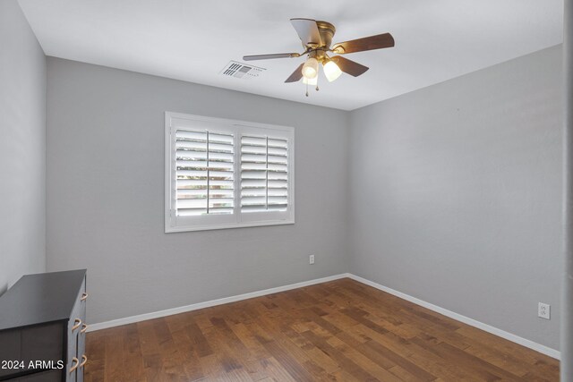 unfurnished room with dark hardwood / wood-style floors and ceiling fan