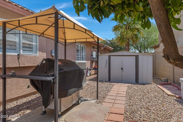 view of patio with a shed and a grill