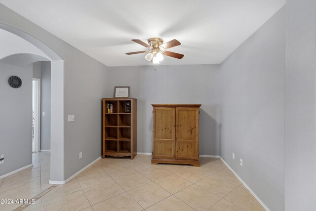 tiled empty room featuring ceiling fan