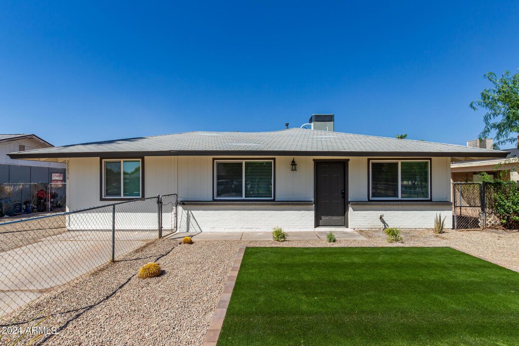 ranch-style home with covered porch and a front lawn