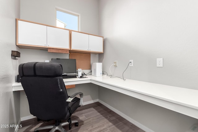 home office featuring built in desk, baseboards, and wood finished floors