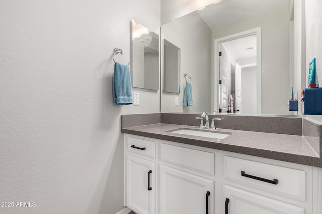 bathroom with vanity and a textured wall