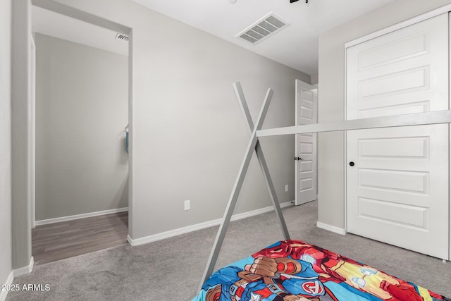 carpeted bedroom with visible vents and baseboards