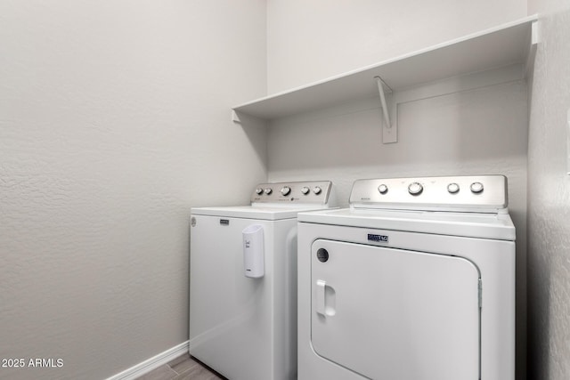 laundry room with a textured wall, baseboards, laundry area, and washer and clothes dryer