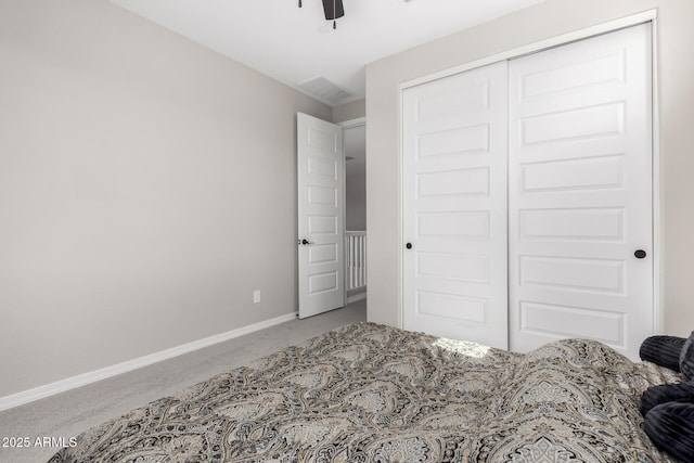 carpeted bedroom with visible vents, baseboards, and a closet