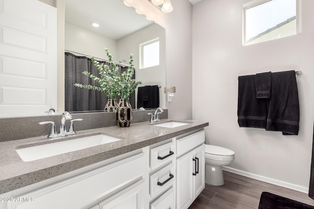 full bath with wood finished floors, toilet, baseboards, and a sink