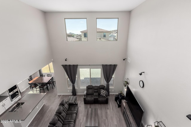 living room featuring plenty of natural light, wood finished floors, and baseboards