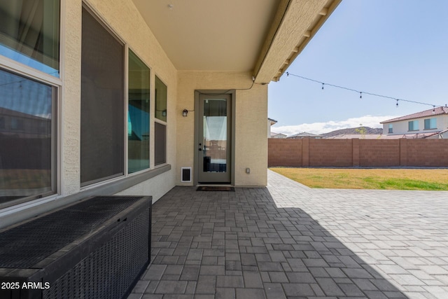 view of patio featuring a mountain view and fence