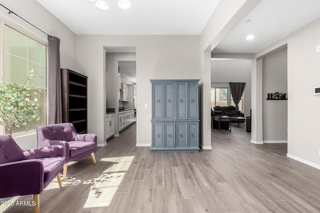 sitting room featuring baseboards and light wood-type flooring