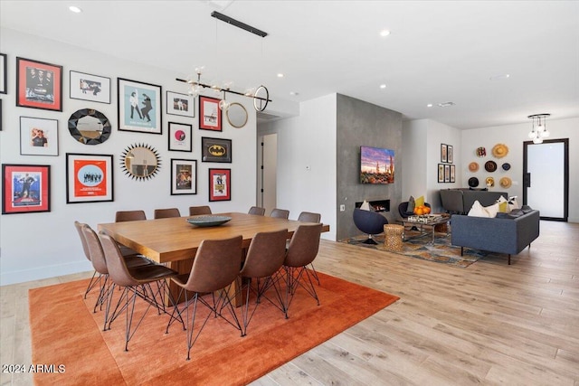 dining room featuring light wood-type flooring and a premium fireplace