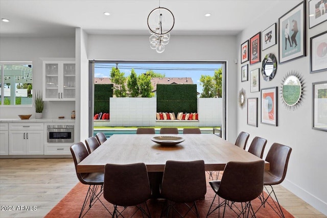 dining area with a notable chandelier and light hardwood / wood-style floors