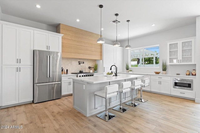 kitchen featuring high quality fridge, light hardwood / wood-style flooring, and white cabinetry