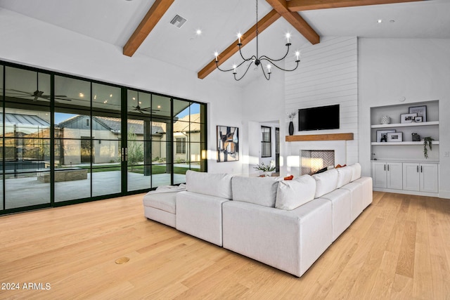 living room with beam ceiling, a fireplace, high vaulted ceiling, light hardwood / wood-style flooring, and an inviting chandelier