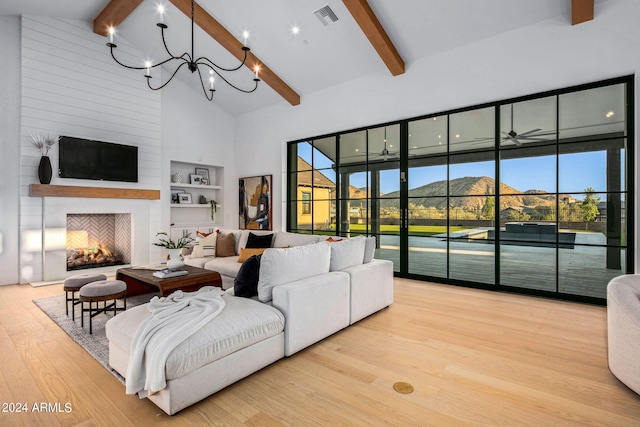 living room featuring beam ceiling, a large fireplace, a mountain view, and light hardwood / wood-style floors