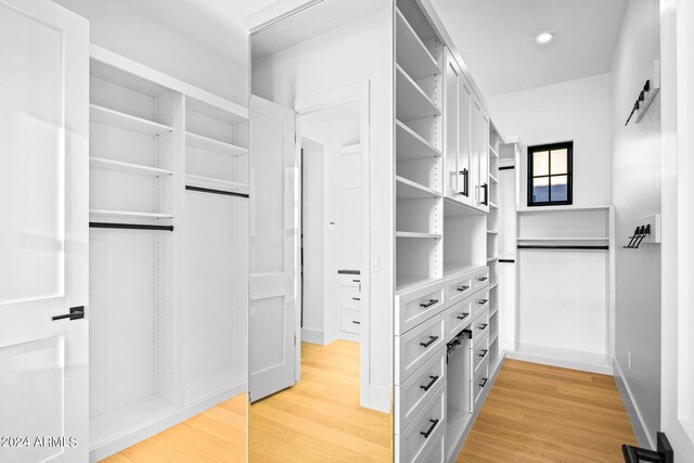 walk in closet with hardwood / wood-style flooring