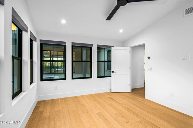 empty room with vaulted ceiling and light hardwood / wood-style flooring