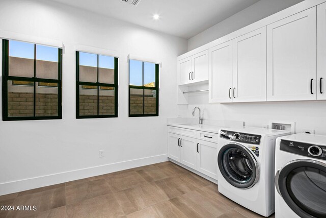 laundry room with washer and clothes dryer, cabinets, and sink