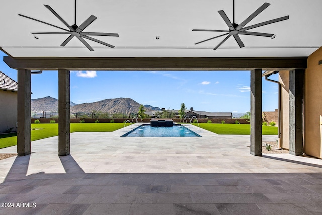 view of pool with ceiling fan, a mountain view, a lawn, and a patio