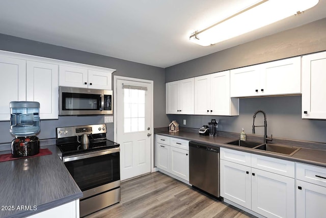 kitchen featuring appliances with stainless steel finishes, sink, and white cabinets