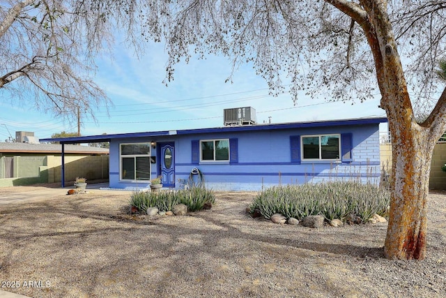 ranch-style home with central AC and a carport