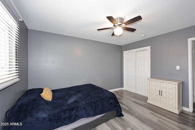 bedroom featuring hardwood / wood-style floors, ceiling fan, and a closet