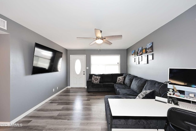 living room featuring ceiling fan and dark hardwood / wood-style flooring