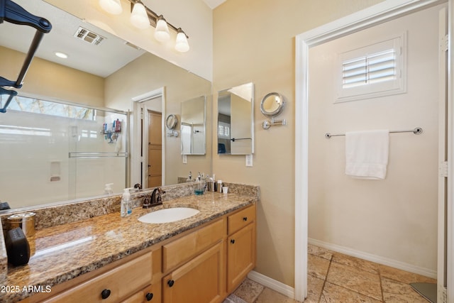 bathroom with a stall shower, baseboards, visible vents, and vanity