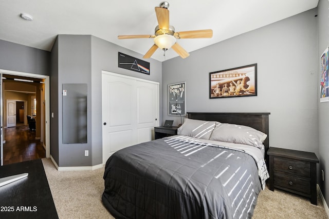 carpeted bedroom with a ceiling fan, baseboards, and a closet