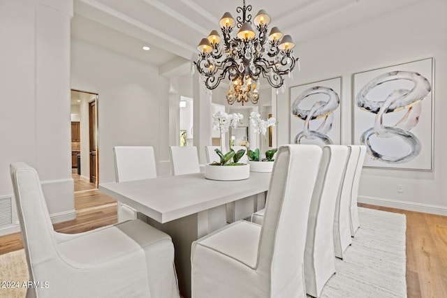 dining room featuring light wood-type flooring, beam ceiling, and a notable chandelier