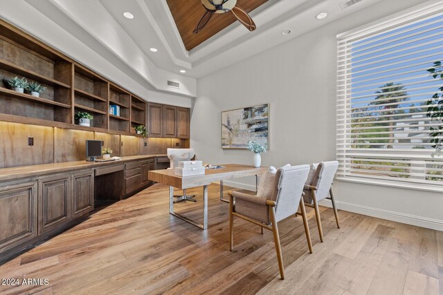 bedroom featuring ceiling fan, light carpet, a tray ceiling, and access to outside