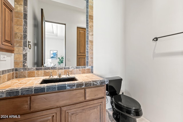 bathroom with toilet, decorative backsplash, and vanity