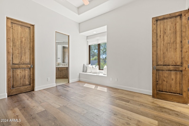 unfurnished bedroom featuring light hardwood / wood-style flooring and connected bathroom