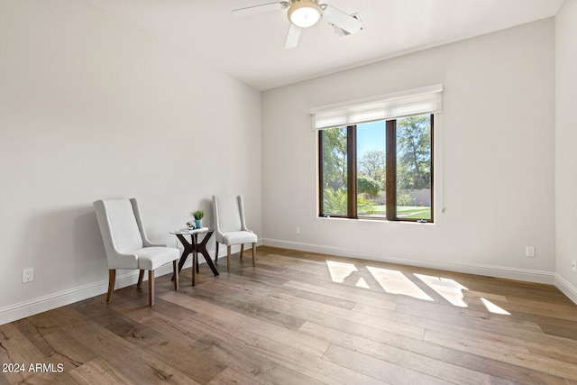 living area featuring light wood-type flooring and ceiling fan