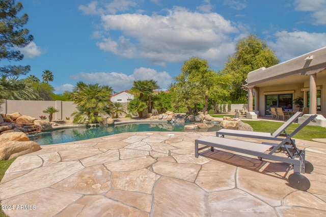 view of swimming pool with pool water feature and a patio