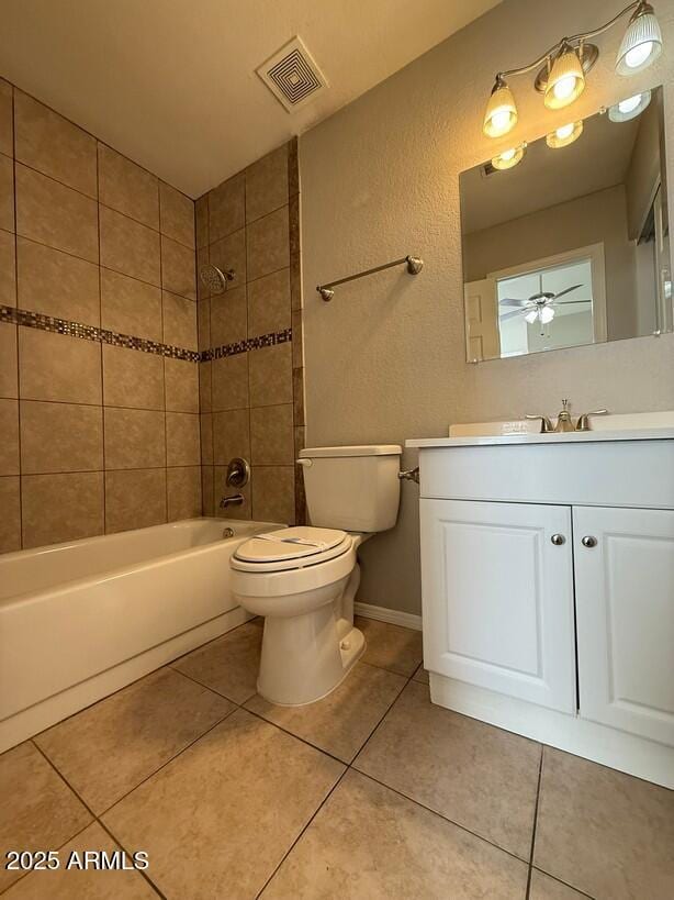 full bathroom featuring vanity, tile patterned flooring, toilet, and tiled shower / bath