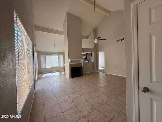 unfurnished living room featuring beam ceiling, ceiling fan with notable chandelier, high vaulted ceiling, and light tile patterned flooring