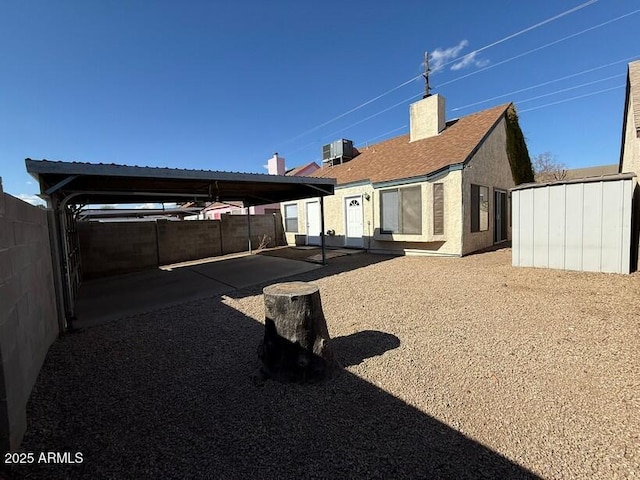 rear view of property with a carport and central AC