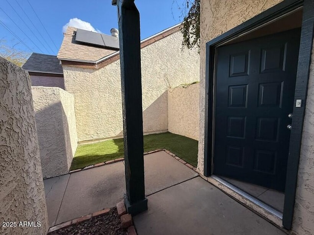 doorway to property with a patio area and solar panels