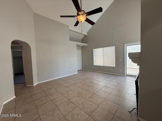 unfurnished living room with ceiling fan, light tile patterned floors, and high vaulted ceiling