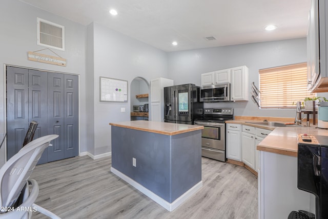 kitchen with a center island, sink, appliances with stainless steel finishes, light hardwood / wood-style floors, and white cabinetry