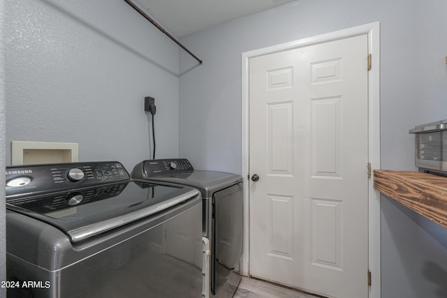 laundry area featuring washer and dryer and light hardwood / wood-style floors