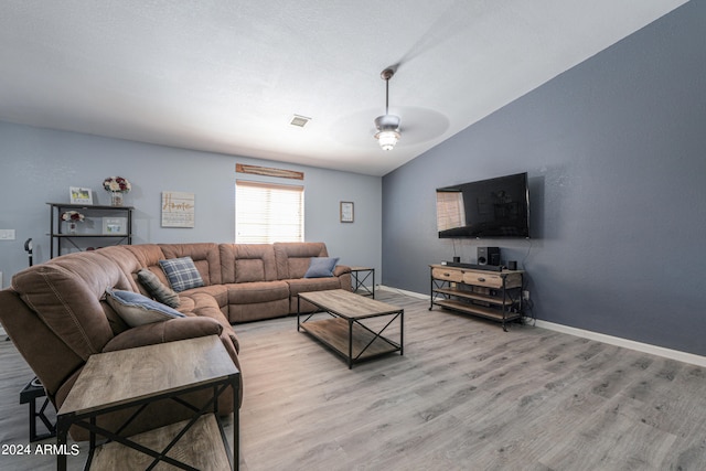 living room featuring ceiling fan, light hardwood / wood-style floors, and lofted ceiling