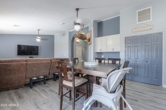 dining room with ceiling fan, lofted ceiling, and light hardwood / wood-style flooring