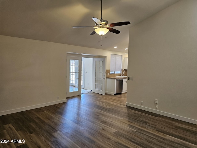 unfurnished living room featuring ceiling fan, dark hardwood / wood-style flooring, french doors, vaulted ceiling, and sink