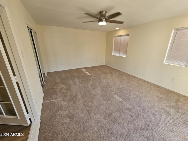 carpeted spare room featuring ceiling fan