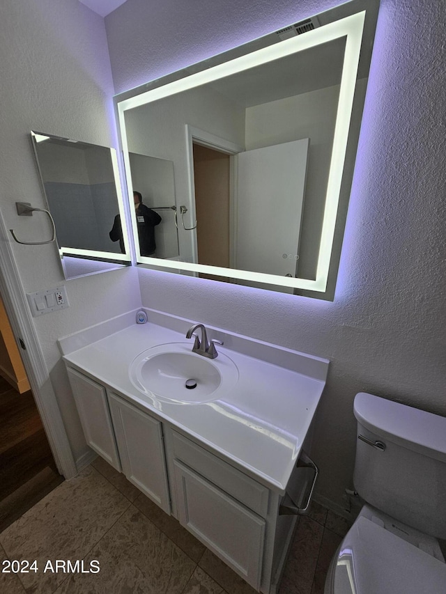 bathroom with tile patterned floors, vanity, and toilet