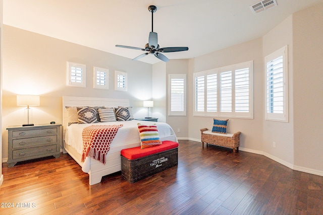 bedroom with ceiling fan, dark hardwood / wood-style flooring, and multiple windows