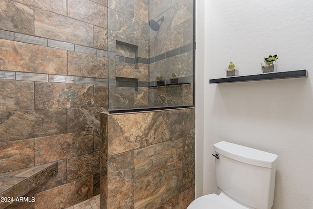 bathroom with toilet and tiled shower