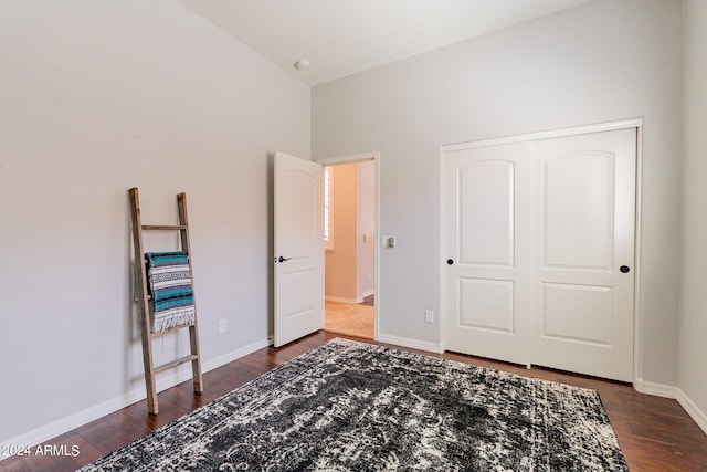 bedroom with a closet, dark hardwood / wood-style floors, and vaulted ceiling