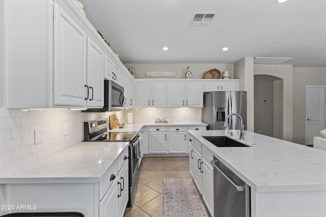 6213 W Gambit Trl, Phoenix, AZ 85083 - kitchen with appliances with stainless steel finishes, a sink, white cabinets, a kitchen island with sink, and decorative backsplash